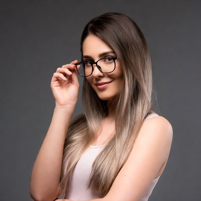 Woman adjusting glasses on gray background