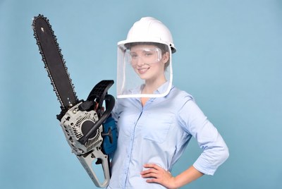 Woman holding chainsaw with safety gear