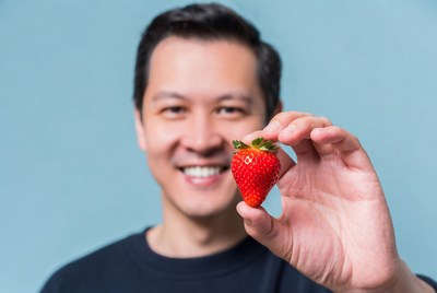 Asian man holding strawberry