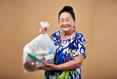Asian woman holding full trash bag
