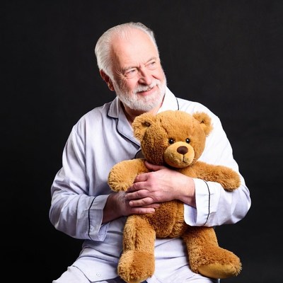 Elderly man hugging teddy bear
