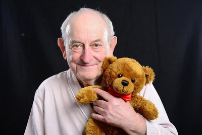 Elderly man holding teddy bear