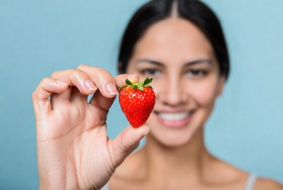 Woman holding fresh strawberry
