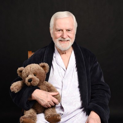 Elderly man holding teddy bear