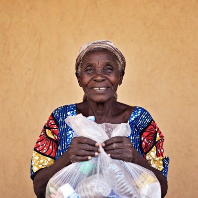 Elderly African woman holding plastic bag