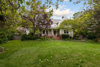 White house with porch in green yard