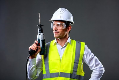 Man holding drill in hard hat