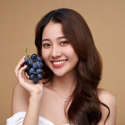 Asian woman holding grapes