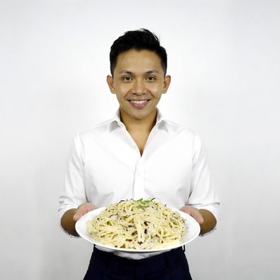 Asian man holding spaghetti plate