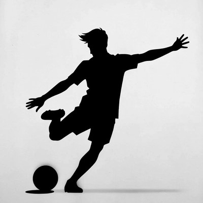 Silhouette of man kicking soccer ball
