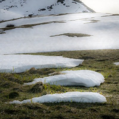 Snow Patches on Grassy Mountain Slope