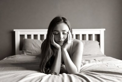 Woman resting chin on hands in bed