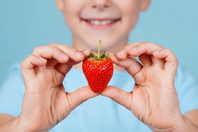 Boy holding fresh strawberry