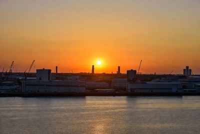 Sunset over industrial harbor cranes