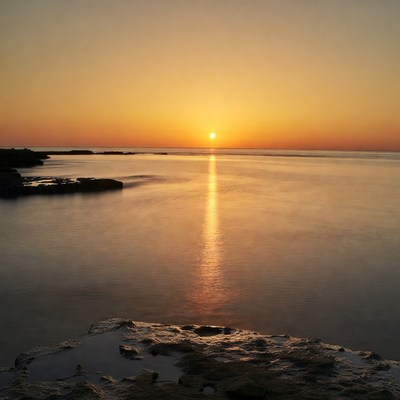 Sunset over ocean with rocks