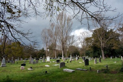 Graveyard with tombstones under cloudy sky
