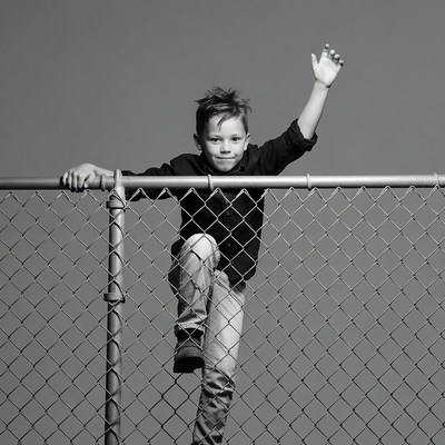 Boy climbing chain link fence