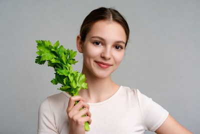 Young woman holding celery