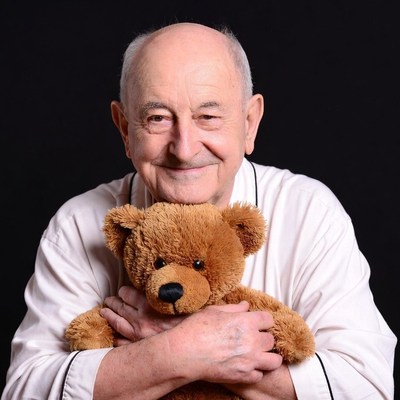 Elderly man holding teddy bear