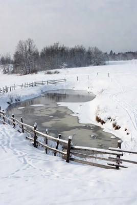 Frozen Pond by Snowy Wooden Fence