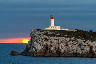 White Lighthouse on Cliff at Sunset