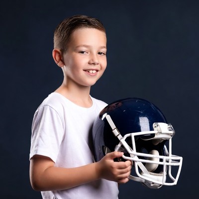 Boy holding football helmet