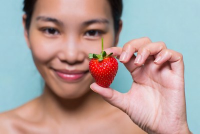 Asian woman holding strawberry