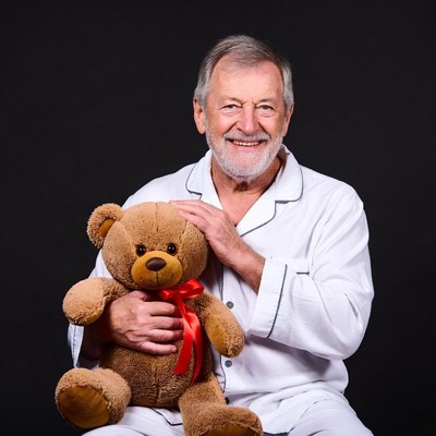 Elderly man holding teddy bear