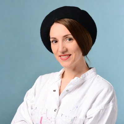 Woman in black beret and paint-splattered shirt