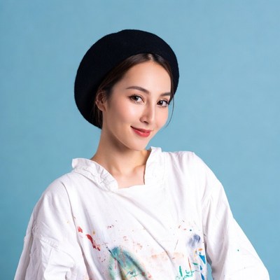 Asian woman in beret and paint-splattered shirt