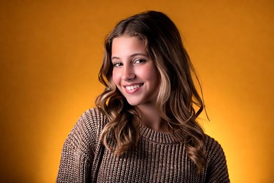 Smiling teenage girl in brown sweater