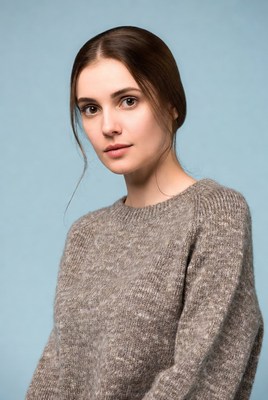 Woman in gray sweater on blue background