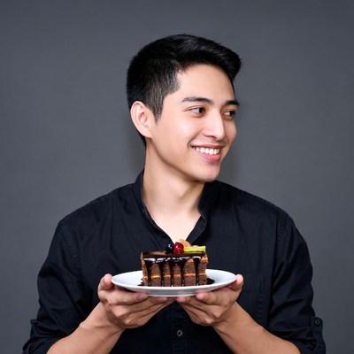 Asian man holding chocolate cake slice