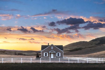 White farmhouse at sunset in hills