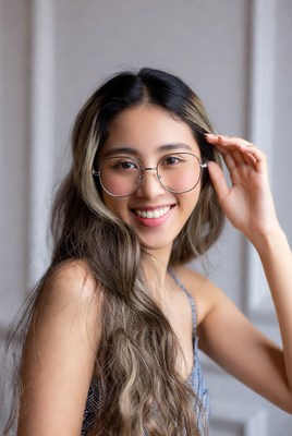 Asian woman smiling with hand on glasses