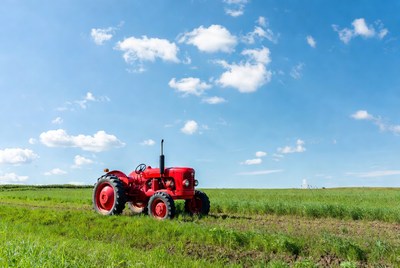 Red vintage tractor in green field