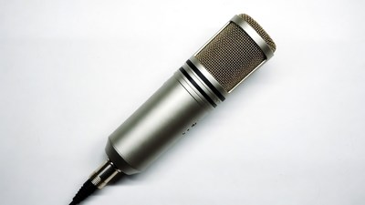Silver condenser microphone on white background