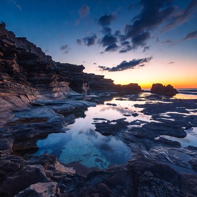Sunset over rocky beach tide pools
