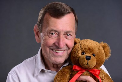 Elderly man holding teddy bear