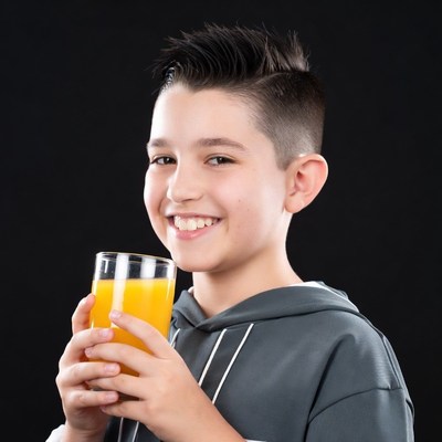 Boy smiling holding orange juice
