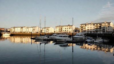 Yachts docked at marina with apartments
