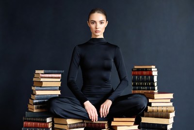 Woman sitting on stack of books