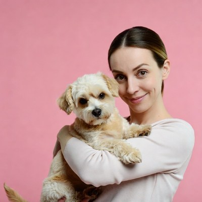 Woman holding cute fluffy dog