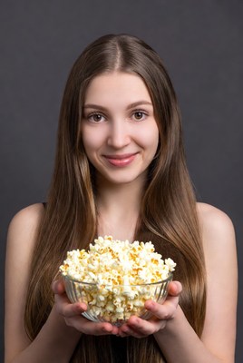 Young woman holding popcorn bowl