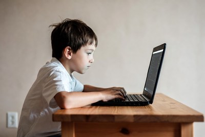 Boy using laptop at table
