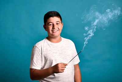 Boy holding lit incense stick