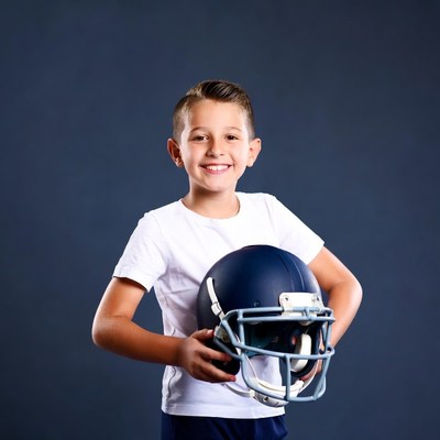 Boy holding football helmet