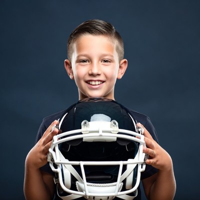Boy holding football helmet