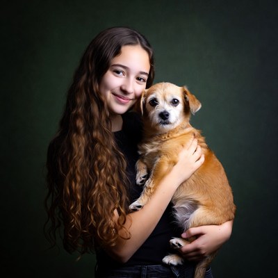 Girl holding small brown dog