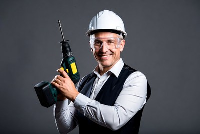Man holding drill wearing hard hat